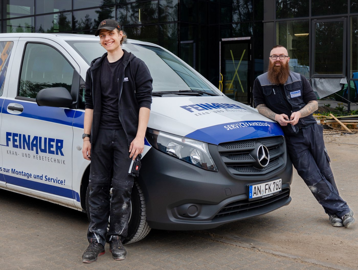 Zwei Feinauer-Servicetechniker vor dem Servicefahrzeug